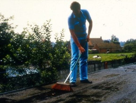Un homme qui nettoie la toiture